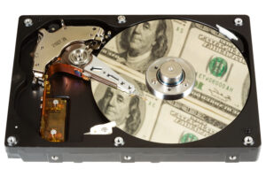 The open hard disk, reflection of dollars. Focus on a disk. Сoncept information=money. Isolated on white.